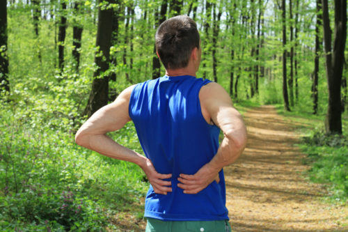 Back pain. Man Runner lower back pain injury